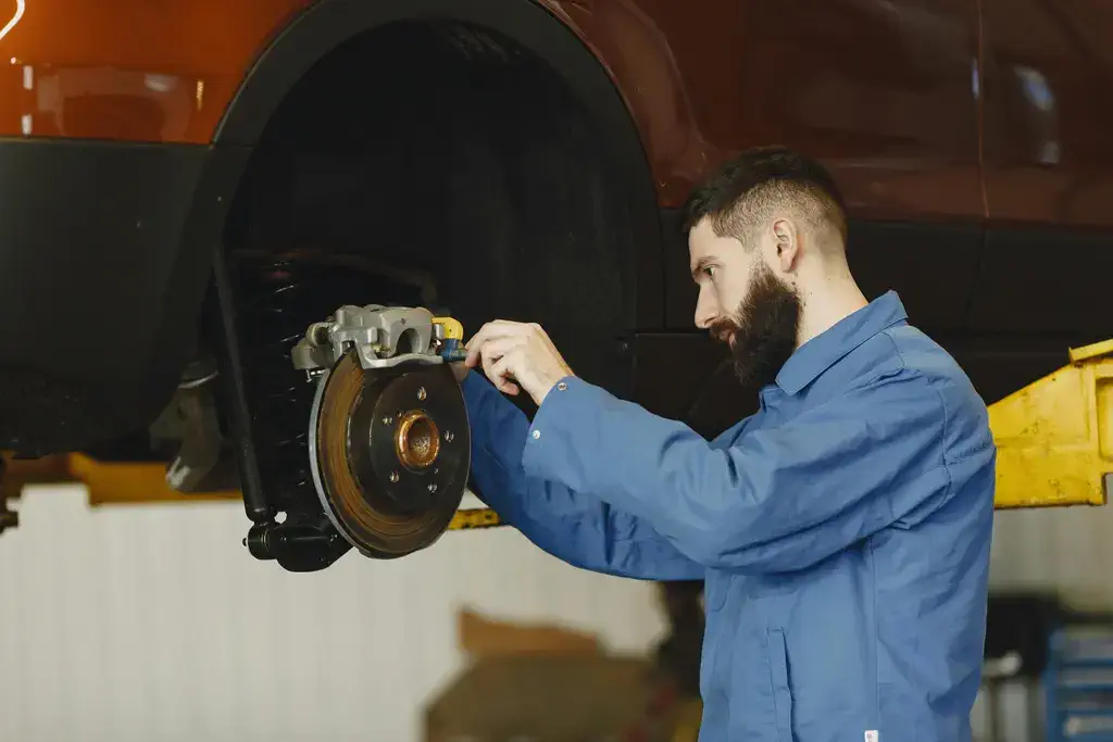 mechanic inspecting brake pads and rotors at University Auto Service in Clifton Cincinnati