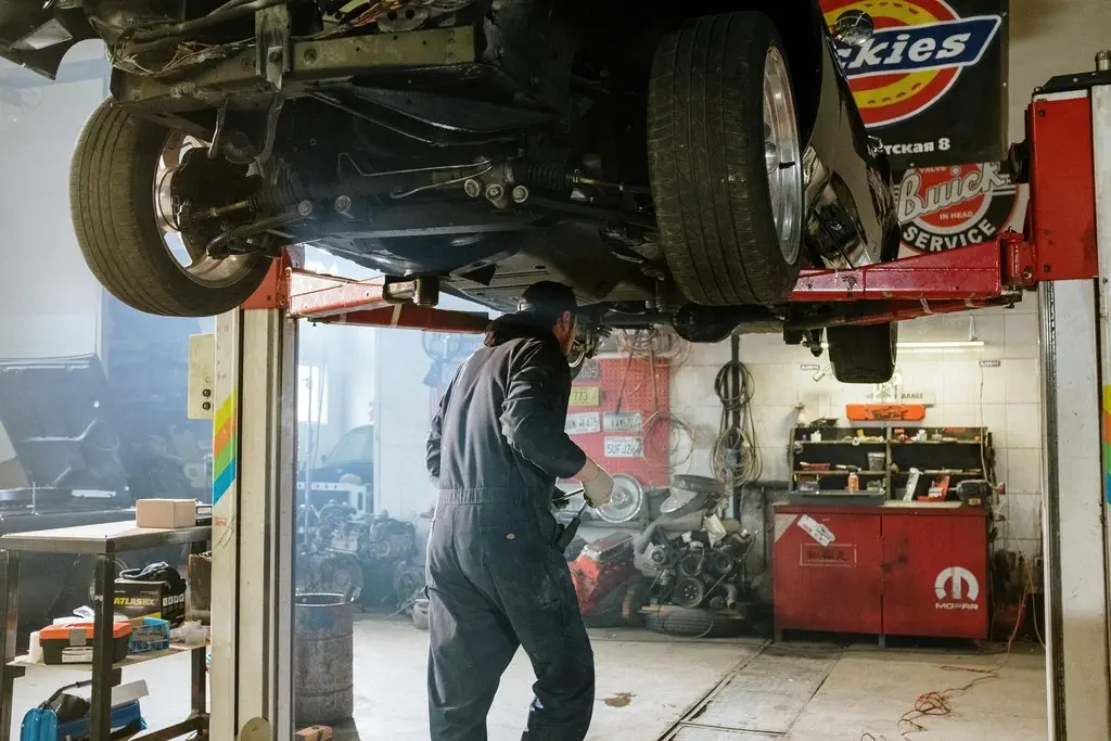 ASE certified mechanic checking oil levels under the hood